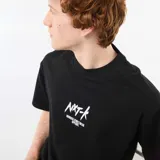 Camiseta negra de cuello redondo y manga corta, con bordado frontal en contraste con la inscripción "NXT-K ORIGINAL STREETWEAR APPAREL".
