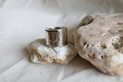 Anillo ancho de alpaca color plateado con textura martillada.