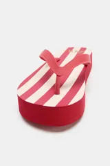 Sandalias tipo ojotas color marrón con plataforma gruesa a rayas horizontales blancas y marrones.