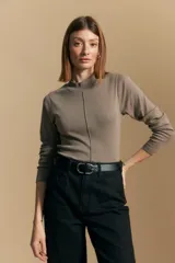 Polera de manga larga color marrón claro, con cuello alto y costura vertical decorativa en el frente.