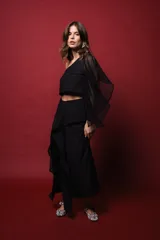 Top negro asimétrico con un hombro descubierto y manga con volado de red.