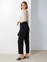 Enterito combinado de fiesta marca Julia Jordan. El torso es de lentejuelas color beige con escote en V cruzado y mangas largas abullonadas. La cintura es elastizada con lazo de ajuste y el pantalón es negro con bolsillos verticales. La espalda tiene cierre invisible y el torso está forrado.