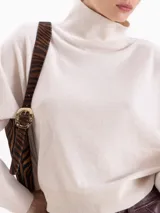 Polera de tejido de punto color marrón, con cuello alto y diseño holgado de corte oversize.