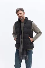 Chaleco puffer de nylon con diseño matelaseado, cuello alto y cierre frontal. Cuenta con bolsillos laterales y un pequeño parche con logo en el pecho.