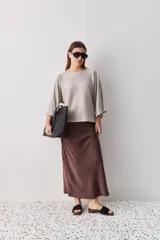 Sweater de punto liviano negro, con escote bote y mangas amplias de largo tres cuartos que aportan una silueta relajada y fluida.