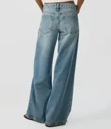Pantalón wide leg de tiro bajo confeccionado en jean de algodón, con diseño de piernas amplias y bolsillos delanteros y traseros.