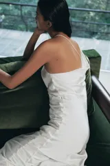 Vestido largo de tejido satinado con escote asimétrico, tirante ancho y tirante fino cruzado en la espalda. Presenta un diseño fluido con forro interior a tono.