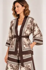 Kimono de seda liviano en color beige y chocolate con estampado de estilo toile de Jouy y detalles de bandas anchas en los bordes y las mangas. Cuenta con mangas 3/4 y lazo ajustable en la cintura.