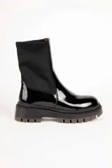 Bota baja de mujer estilo paddock, color negro, con suela track gruesa y caña de tejido elástico.