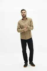 Camisa de manga larga lisa con cuello clásico y cierre frontal de botones. Presenta un ajuste regular y un pequeño logo bordado en el pecho.