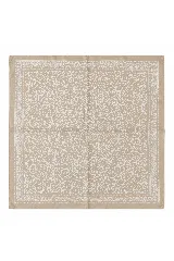 Pañuelo cuadrado de tela con estampado de motivos vegetales y florales en color blanco sobre fondo beige, con borde decorativo estilo paisley.