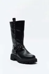 Bota alta negra de estilo biker, con suela track gruesa, detalles de tachas metálicas en las tiras del tobillo y a lo largo de la caña, y presilla trasera.