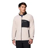 Campera de polar Columbia con cierre frontal completo, cuello alto y bolsillo en el pecho con cierre. Presenta un diseño en color beige con detalles en negro en el bolsillo, cuello, puños y dobladillo.