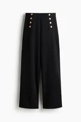 Pantalón de punto grueso color negro, de tiro alto con elástico oculto, botones decorativos dorados en la parte delantera y piernas rectas de corte holgado.