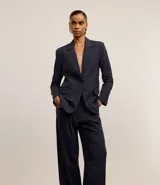 Pantalón de vestir azul marino, de corte wide leg, con cintura alta, pliegues frontales, bolsillos laterales y aplicación de strass.