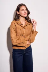 Camisa color camel de gamuza sintética, corte al cuerpo, con flecos en el pecho y mangas largas.
