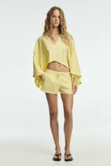 Shorts de tiro bajo confeccionado en lino, con cintura elástica ajustable mediante cordones y aberturas laterales en el bajo.