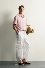 Polo de corte regular fit en color rosado con efecto lavado. Presenta cuello solapa, cierre frontal de botones y mangas cortas con acabados en rib.