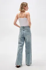 Pantalón de jean de corte ancho y tiro alto, con diseño de costuras decorativas en las piernas.