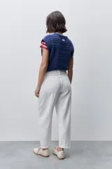 Pantalón jean de tiro alto con calce straight y pierna recta, confeccionado en denim de aspecto limpio. Cuenta con cinco bolsillos, cierre frontal con botón y presillas para cinturón.