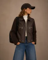 Campera de cuero color chocolate con mangas de lana tejida. Presenta cierre frontal, bolsillos con cierre en el pecho y detalle de ojales metálicos en el ruedo.