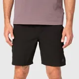 Short deportivo negro con cintura elástica, cordón ajustable y aberturas laterales. Presenta un pequeño logo circular en la parte inferior de la pierna izquierda.