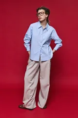 Camisa de manga larga color blanco, con cuello clásico y cierre frontal de botones de nácar. Presenta un corte cómodo y versátil.