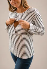 Buzo de lactancia a rayas horizontales blancas y negras, con cuello redondo y mangas largas. Presenta un diseño funcional con apertura horizontal en el pecho para facilitar la lactancia.
