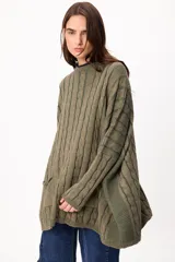 Sweater de tejido artesanal con diseño de rayas verticales en tonos camel y beige, corte holgado, cuello redondo y puños altos ajustados.