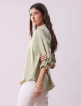 Blusa color beige de poliéster con escote en V y mangas 3/4 regulables con presilla y botón.