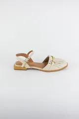 Sandalias de cuero color celeste, con punta cerrada, flecos frontales y detalle de estribo metálico dorado. Tienen tira ajustable al tobillo y suela plana con pequeño taco.