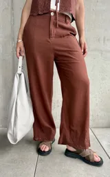 Pantalón de lino color chocolate, de corte recto y terminación bordada en el ruedo.