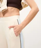 Pantalón recto deportivo de modal color beige, con cintura elástica sin cierre y recortes laterales en contraste.