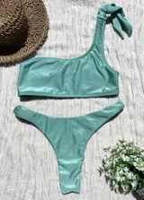 Conjunto de bikini verde agua, con corpiño de un hombro y bombacha colaless.
