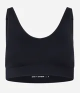 Top deportivo negro, confeccionado en tejido seamless de poliamida y elastano, con escote en U y breteles ajustables. Presenta una banda inferior texturizada y copas removibles.