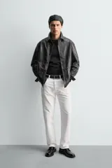 Sobrecamisa de corte regular confeccionada en piel napa negra, con cuello solapa, cierre frontal de botones y mangas largas con puños abotonados.