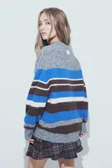 Sweater de tejido de punto con diseño de rayas horizontales en tonos rojo, blanco, azul marino y marrón. Presenta cuello redondo, mangas largas y un calce relajado.