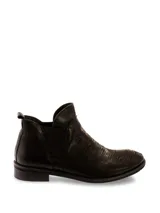 Botas Chelsea cortas de cuero negro, con elástico lateral y textura arrugada o plisada en la parte delantera. Poseen un taco bajo y bajo de goma.