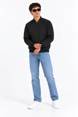 Campera bomber manga larga de algodón color negro, con cierre frontal y puños y cuello elásticos.