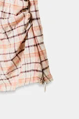 Top o cuerpo de manga corta abullonada con cuello redondo y frunces laterales. Presenta un estampado a cuadros en tonos beige, naranja claro y marrón oscuro.