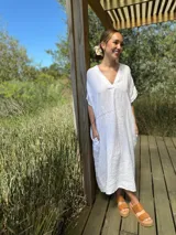 Vestido blanco de lino 100% italiano, con escote en V, mangas cortas y corte relajado con bolsillos amplios.