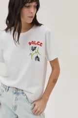 Remera blanca de algodón con cuello redondo y mangas cortas. Estampado en el frente con la palabra "Dolce" en rojo y un diseño floral en negro y verde.