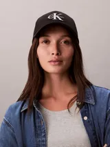 Gorra de béisbol negra con visera curva y logo de Calvin Klein bordado en blanco en el frente.
