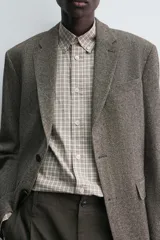 Blazer de corte regular fit confeccionada en tejido de mezcla de lino y lana. Presenta cuello con solapas de muesca, cierre frontal de un botón, bolsillos de solapa en la cadera y bolsillo de vivo en el pecho. Cuenta con mangas largas con puños abotonados, bolsillo interior y abertura central en la espalda.