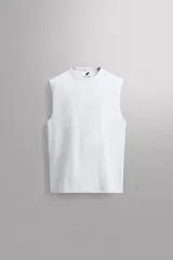 Camiseta sin mangas tipo tank top de corte relaxed fit, confeccionada en tejido compacto de algodón color gris melange, con cuello redondo.