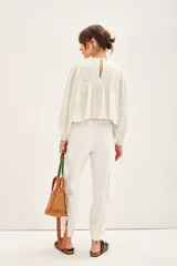 Pantalon tipo cargo color negro, de corte holgado, con bolsillos laterales y en las piernas. Posee cierre y botones en el frente, cintura elástica y puños elásticos en el ruedo.