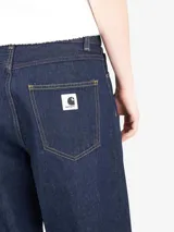 Pantalón de denim de corte holgado y pierna recta, con cintura regular y cierre de cremallera. Presenta costuras en contraste y un diseño de estilo relajado.