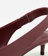 Zapato slingback de cuero color bordó, con diseño elegante, puntera fina y taco bajo tipo kitten heel. Cuenta con tira trasera elástica para mayor comodidad y ajuste.