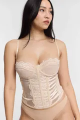 Corset color beige con copas con encaje y cuerpo con paneles de satén y encaje.