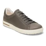 Zapatilla de cuero color gris oscuro, con cordones al tono, suela de goma blanca con detalle de corcho en el lateral y diseño minimalista.